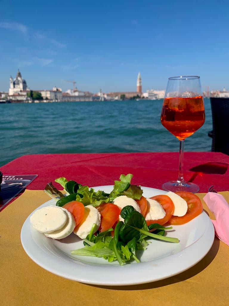 Eating in Giudecca with a view of San Marco, Venice. Giudecca is a top place to stay in venice Italy for a laid-back and local atmosphere 