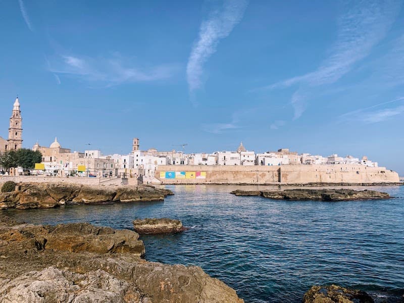 I Drove All Over Puglia, Italy — Here Are 6 Road Trip Itineraries That Actually Work Historic sea walls, whitewashed buildings, and the Cathedral of Maria Santissima della Madia in Monopoli, Puglia, Italy.