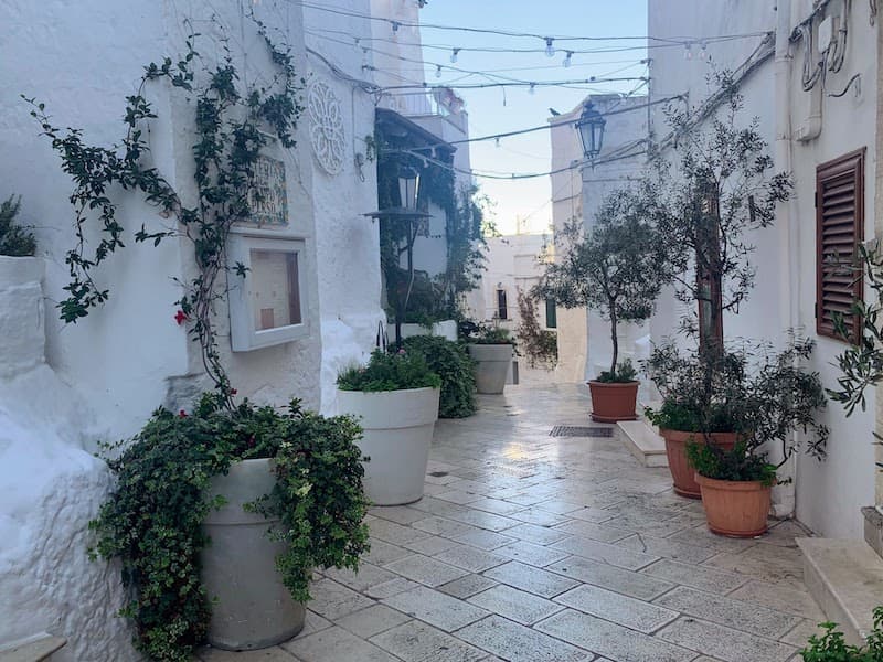 I Drove All Over Puglia, Italy — Here Are 6 Road Trip Itineraries That Actually Work Scenic whitewashed alleyway in the historic hilltop town of Ostuni, Puglia, Italy.