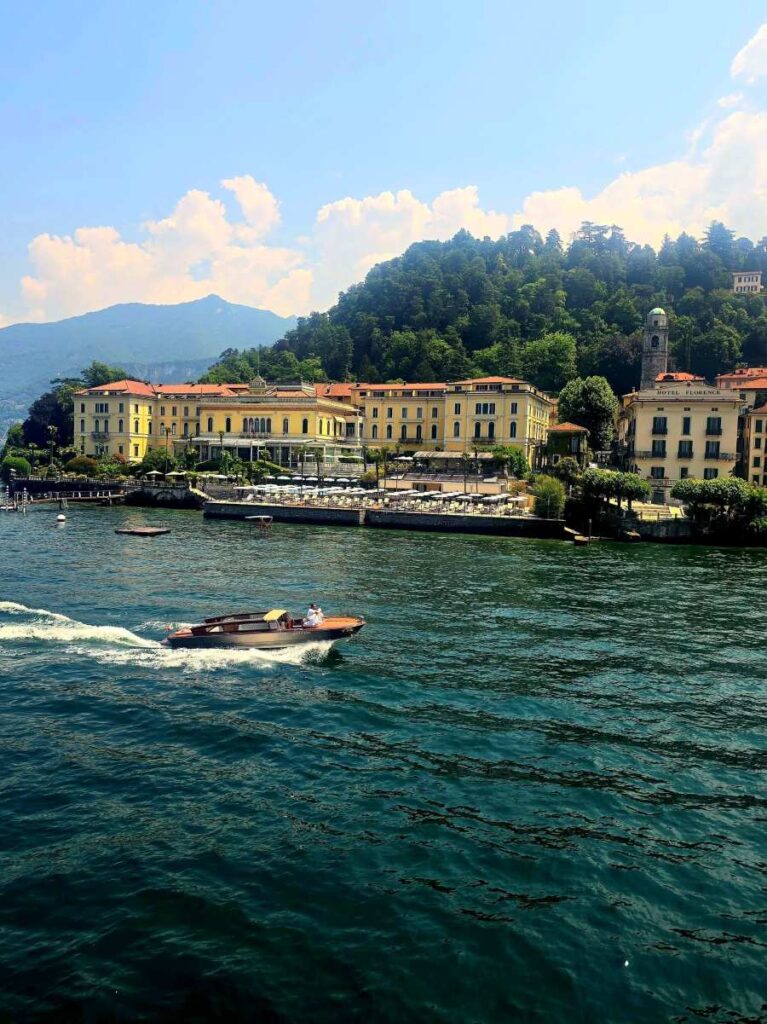 The Grand Hotel Villa Serbelloni in Bellagio, Lake Como, with a wooden speedboat cruising in front of it