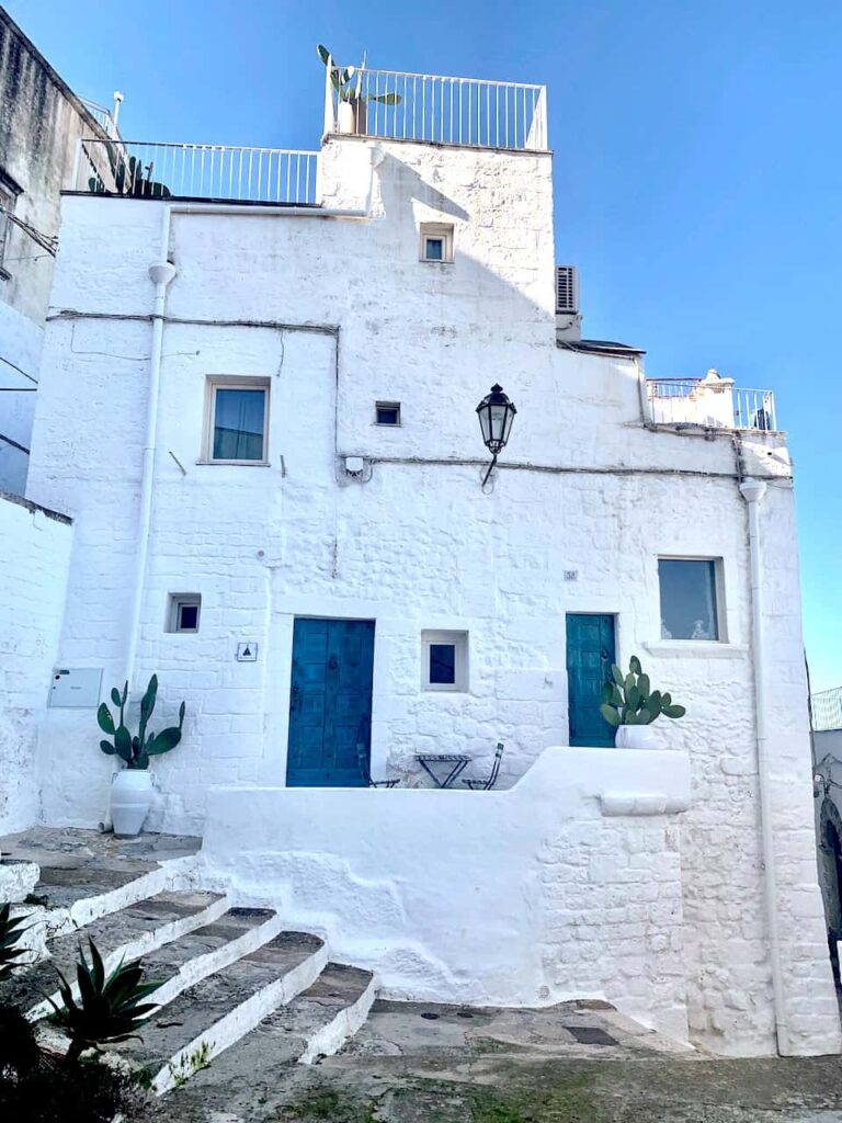 Traditional whitewashed alley in the historic center of Ostuni, Italy, known as the White City in Puglia.