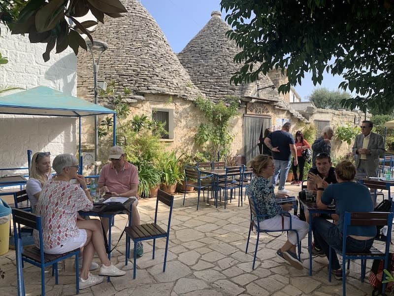 Outdoor café beside trulli stone buildings in Alberobello, Puglia, Italy
