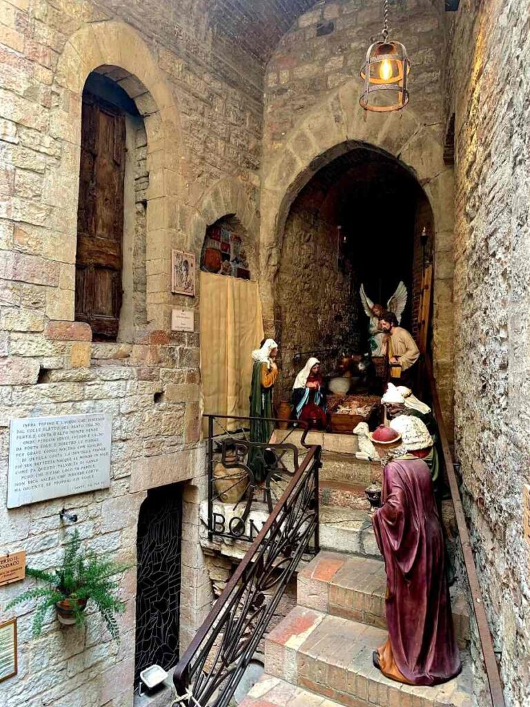 Historic stone corridor with life-sized nativity figures in the supposed childhood home and fabric shop of St Francis, Assisi, Italy