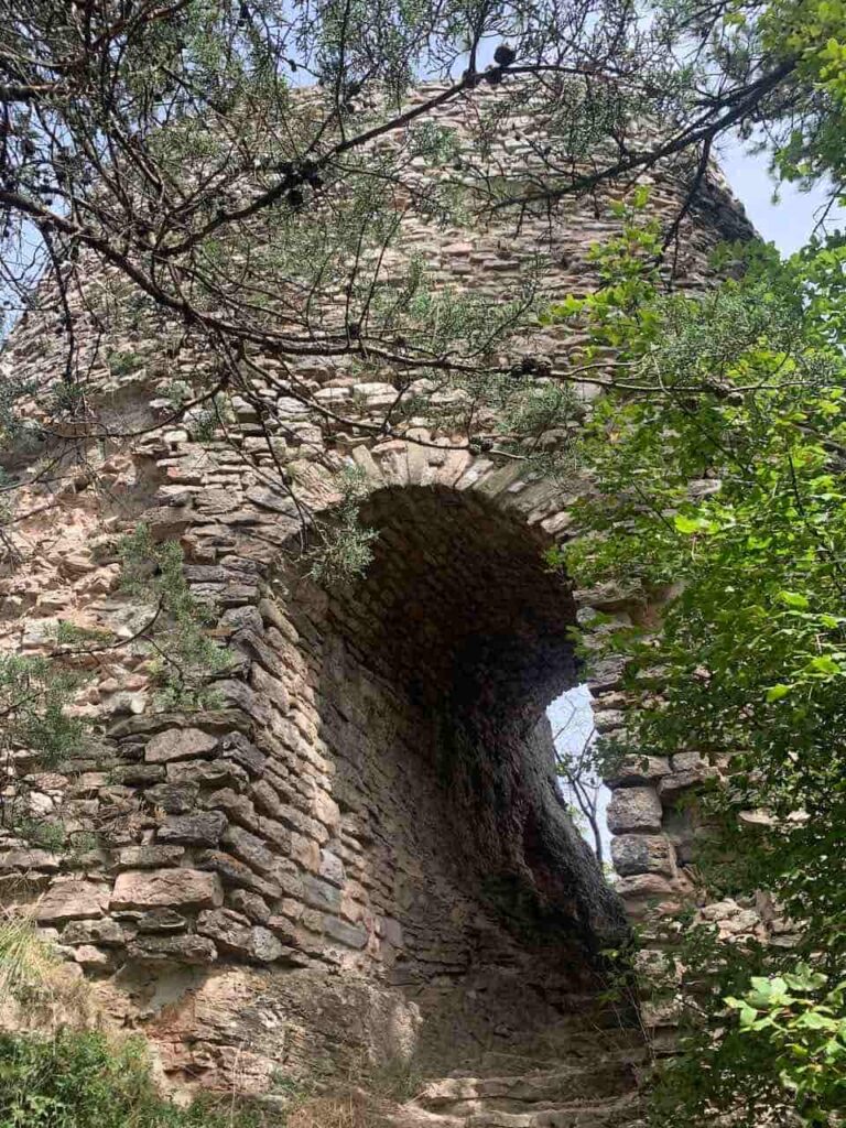 Stone fortress on Mount Ingino above Gubbio, Italy, with the wooded hillside and Umbrian landscape around it