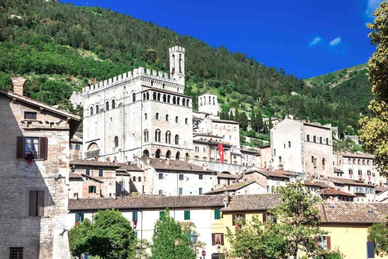 Large gray stone Palazzo dei Consoli with its tall tower at the center of Gubbio, Umbria, Italy