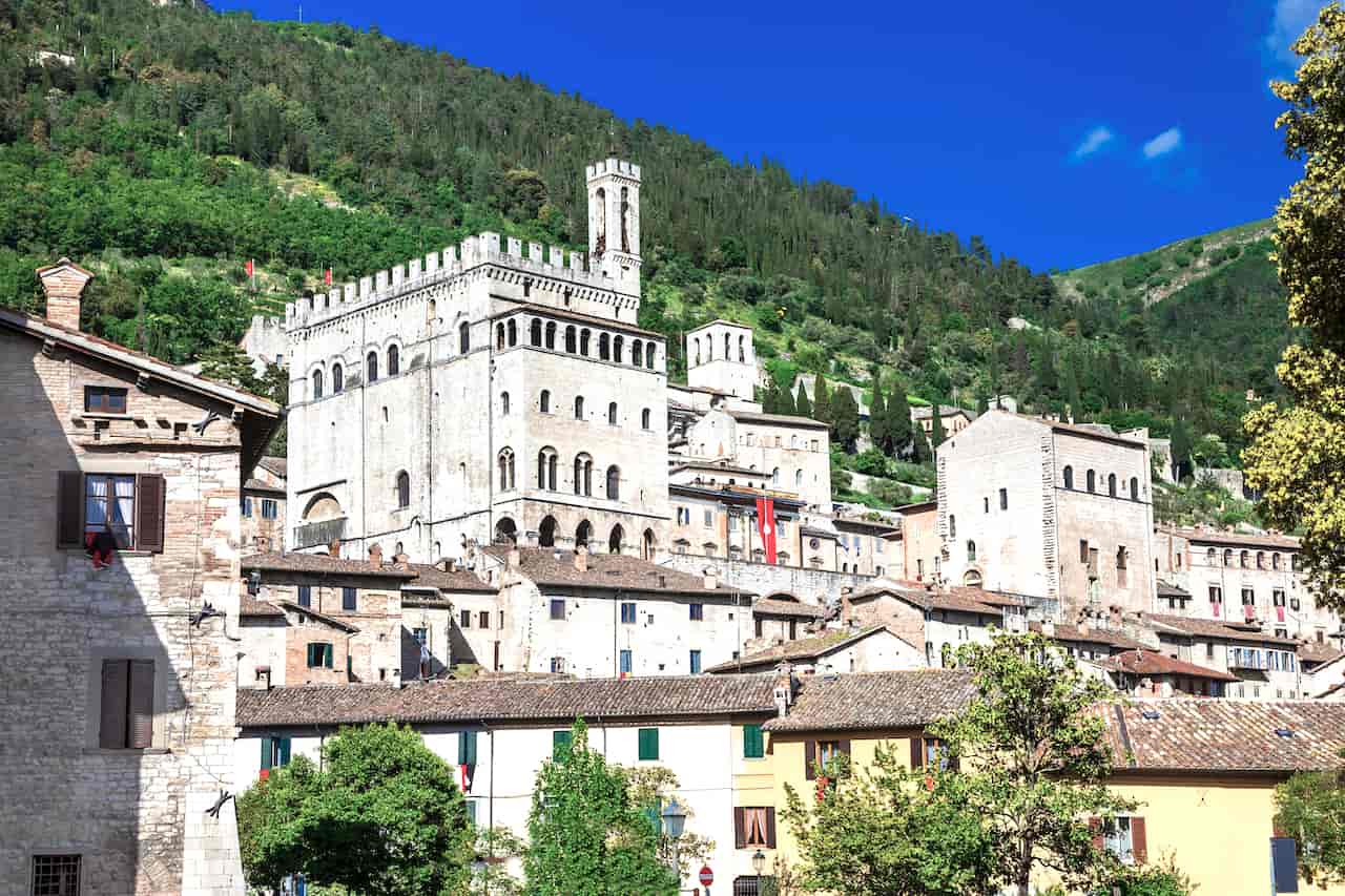 Large gray stone Palazzo dei Consoli with its tall tower at the center of Gubbio, Umbria, Italy
